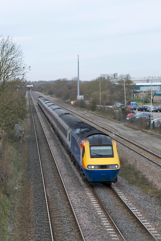 43075, EM 11.32 Nottingham-London St. Pancras (1B38), site of Isham & Burton Latimer station (C. 20.11.1950) 
 Only the second HST working observed in the last two hours to pass me on the Midland Mainline near to Kettering. This service is the 1B38 11.32 Nottingham to St. Pancras and is being led by power car 43075. The train is seen passing the site of Isham and Burton Latimer station with the Weetabix factory just in view to the right, a significant local employer. 
 Keywords: 43075 11.32 Nottingham-London St. Pancras 1B38 site of Isham & Burton Latimer station East Midlands Trains HST