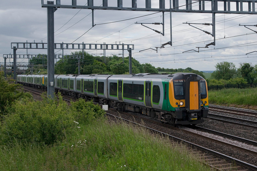 350129 & 350376, LM 11.24 London Euston-Birmingham New Street & Crewe (2Y11 & 1U33, 2L), Ashton Road Bridge 
 A particularly dull June day in South Northamptonshire finds 350129 and 350376 pass between Ashton and Roade with the 11.24 Euston to Birmingham and Crewe. This is a through train that splits at Birmingham New Street. 
 Keywords: 350129 350376 2Y11 1U33 Ashton Road Bridge