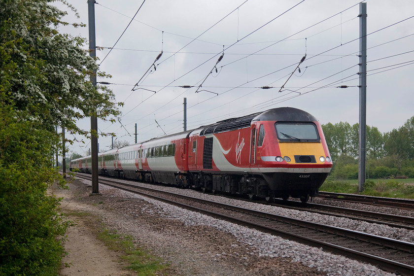 43307, GR 11.35 London Kings Cross-Leeds (1D12, 1L), White House Crossing TL227777 
 I think that out of all the liveries that the HSTs have carried that the Virgin East Coast one is the smartest. The red and white looks contemporary and keeps the ageing HST looking fresh. Here, passing White House Crossing near to Abbots Ripton, 43307 (ex. 43107, set 254026) speeds northwards with the 11.35 London King's Cross to Leeds. 
 Keywords: 43107 1D12 White House Crossing TL227777