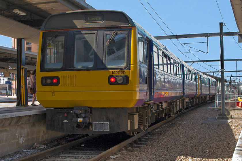 142020, NT 11.48 Leeds-Sheffield (2N23), Leeds station 
 142020 and another unit wait in one of Leeds' bay platforms to work the 2N23 11.48 to Sheffield. The original image needed a fair bit of Photoshop manipulation to bring the bright blue sky back from the white maras as taken. 
 Keywords: 142020 11.48 Leeds-Sheffield 2N23 Leeds station Northern Trains Pacer