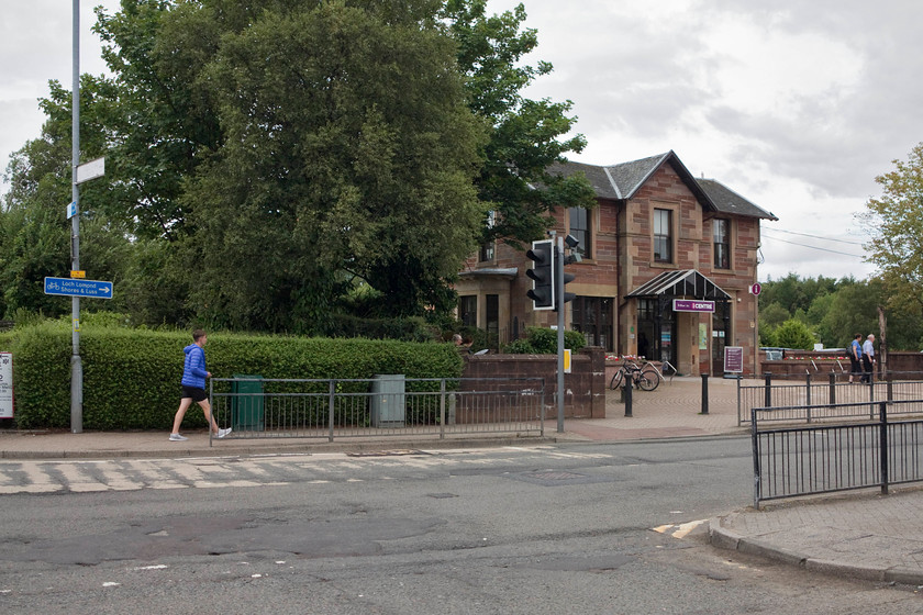 Former Balloch Central station building & level crossing (Closed 23.04.88) 
 Andy and I took afternoon tea in Balloch before returning back towards Glasgow! On walking back to the station, we spotted the tourist information office and recognised it as the old station. The railway crossed the road in the immediate foreground on a level crossing with the platforms in the trees beyond. The line then continued the short distance to Balloch Pier station which, as its name suggests, was above the waters of Loch Lomond. Due to cost cutting by BR in the 1980s, Pier and Central were closed in April 1988 and a new 'bus shelter' station opened that is just behind where I am standing. I am not convinced that the present station is quite as becoming as it should be given the high number of visitors who come to Balloch, many from abroad? 
 Keywords: Balloch Central station