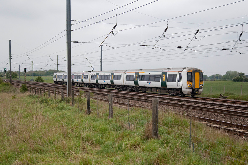 387126, GE 17.34 London Kings Cross-Peterborough (1P30, 3L), Langford TL191396 
 387126 works the 17.34 King's Cross to Peterborough on the down slow past Langford in Bedfordshire. I like the old and new in this picture. The weather beaten fence posts contrast with the white and green ex. Southern class 387. 
 Keywords: 387126 1P30 Langford TL191396