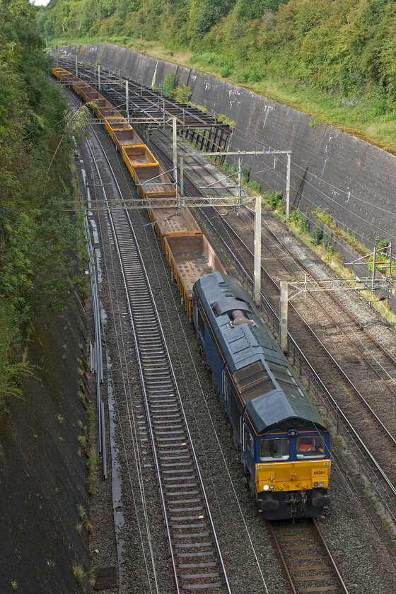 66304, 13.03 Bescot Yard-Wolverton (via Wembley) (6G54, 24L), Roade cutting 
 The third infrastructure train in less than an hour, passes southwards through Roade cutting on the up fast routed via Weedon due to quiet tracks because of further industrial action. GBRf's 66304 leads the 13.03 Bescot Yard to Wolverton via a mysterious extra return trip to Wembley Yard. The infrastructure workings are in association with Bank Holiday work due to take place at Hanslope Junction. 
 Keywords: 66304 13.03 Bescot Yard-Wolverton via Wembley 6G54 Roade cutting GBRf