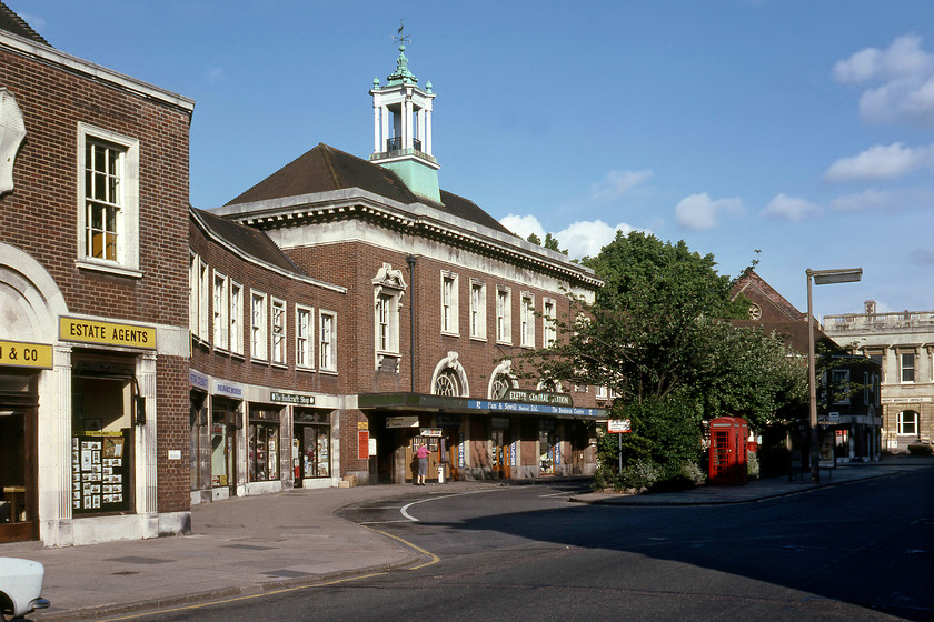 Frontage, Exeter Central station 
 Located on Exeter's Queen Street (the name of the station until 1933) Central station looks more akin to a town hall. This attractive building dates from when the Southern Railway replaced the original building that had become too cramped and was damaged by fire in 1927. Notice the British Railways (Southern) large nameboard above the entrance. Today the entrance road has become pedestrianised and the shops have changed with the estate agents to the left now a trendy bar and bistro. In the last year or so the rather grand copper caped tower and weather vane have been removed that really spoils the balance of the building. I sincerely hope that this is a temporary measure with only repair work needed - can anybody with local knowledge please advise? A few weeks after this photograph was taken I revisited Central station to take a picture of the former Southern Railway green nameboard atop of the canopy, see.....https://www.ontheupfast.com/p/21936chg/29477847404/sr-sign-exeter-central-station 
 Keywords: Frontage Exeter Central station