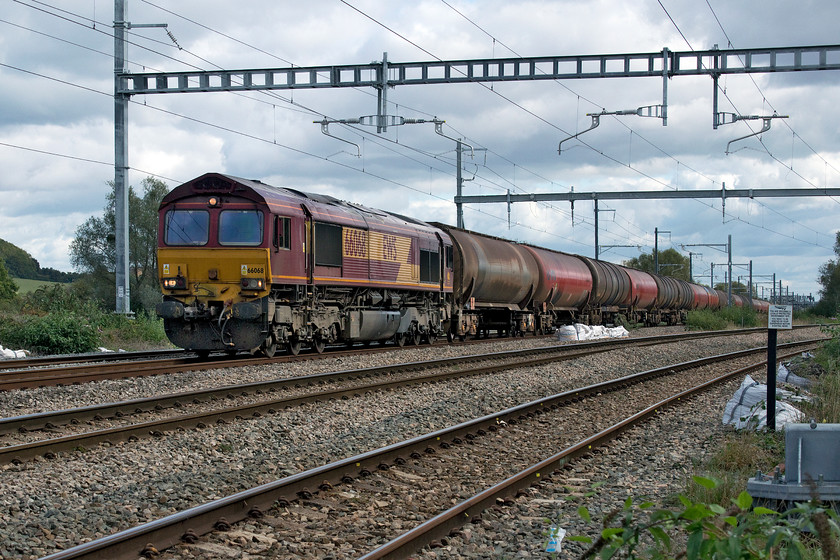 66068, 11.15 Westerleigh-Robseton (6B41), Bishton-crossing 
 Having realised that the camera on shutter priority auto. setting did not cope well with the previous picture of an HST from this angle, I opted for manual control on this image. I went for the foreground being slightly overexposed (about half a stop) and the sky underexposed (about a stop). It was then a relatively easy job in Photoshop to pull things back in order to present the final image as seen here. 66068 passes Bishton on the down fast with the 6B41 11.15 Westerleigh to Robseton oil empties. The two tracks to the right are the 'slow' lines with the left-hand one crossing the fast line in about a mile's time on 1961 built Bishton flyover. Thus, on the run into Severn Tunnel Junction the fast lines are in the centre with the up and down slows to the left and right. 
 Keywords: 66068 11.15 Westerleigh-Robseton 6B41 Bishton-crossing.jpg