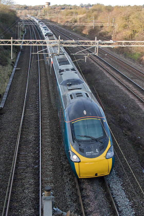 390155, VT 12.16 Manchester Piccadilly-London Euston (1A25, 3E), Victoria bridge 
 My first image of an Avanti West Coast Pendolino at Victoria bridge just south of Roade in Northamptonshire. It is about to sweep under the bridge forming the 1A25 12.16 Manchester Piccadilly to London Euston. With time, the entire fifty-six train sets will be in this new smart teal livery. However, it is not yet clear as to whether there will be a naming poicy for some or all of the fleet. 
 Keywords: 390155 12.16 Manchester Piccadilly-London Euston 1A25 Victoria bridge Avanti West Coast Pendolino