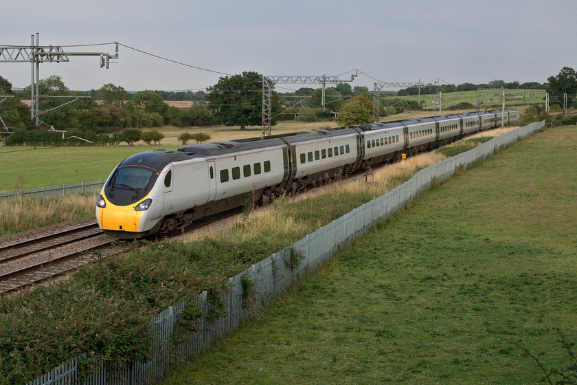 390056, VT 18.58 London Euston-Birmingham New Street (9G40, RT), Wright's Lane bridge 
 This location at Wright's Lane bridge near the Northamptonshire village of Gayton is one that I visited many times during the final years of operation of Virgin West Coast's locomotive-hauled trains. However, due to the monotony of Pendolinos and Voyagers and, more importantly, the installation of palisade fencing I have not been here for a long time. However, on returning from seeing Grand Central's test train I stopped off for a short while. Whilst the fencing still ruins the attractiveness of the location it does remain a smashing spot for a late afternoon or evening train. 390056 powers past working Avanti's 18.58 Euston to Birmingham New Street service. 
 Keywords: 390056 18.58 London Euston-Birmingham New Street 9G40 Wright's Lane bridge Virgin Avantai West Coast