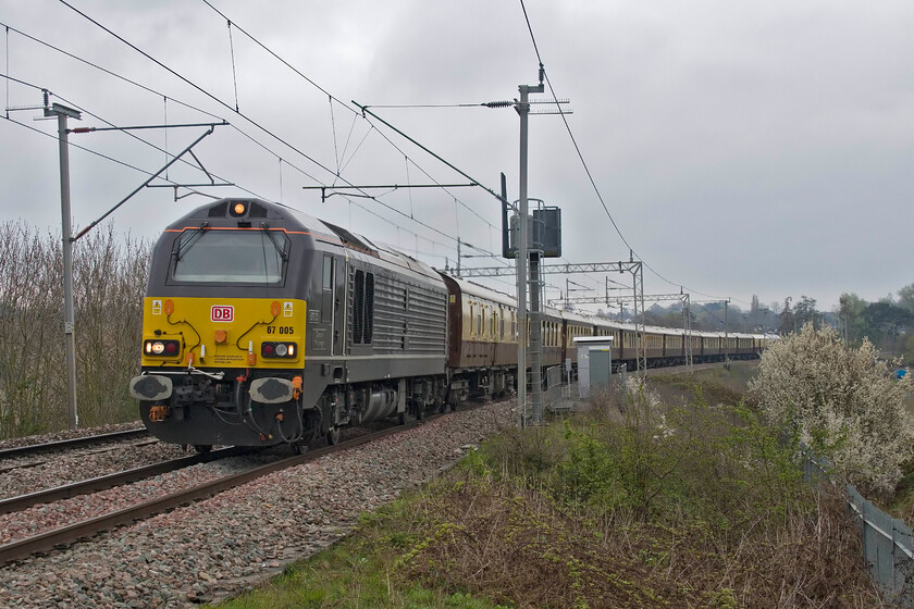 67005, 07.50 London Victoria-Liverpool South Parkway (1Z39, 4L), Wilson's Crossing 
 67005 Queen's Messenger leads the 1Z39 nagex taking racegoers from the London area to Merseyside for the 2023 Grand National at Aintree. The charter left Victoria at 07.50 arriving at Liverpool South Parkway at lunchtime for onward transportation to Aintree. I am sure that some lucky passenger would have gone home later in the day having placed their bet on Coarach Ramber as the winner at 8:1. 
 Keywords: 67005 07.50 London Victoria-Liverpool South Parkway 1Z39 Wilson's CrossingDB Belmond Pullman