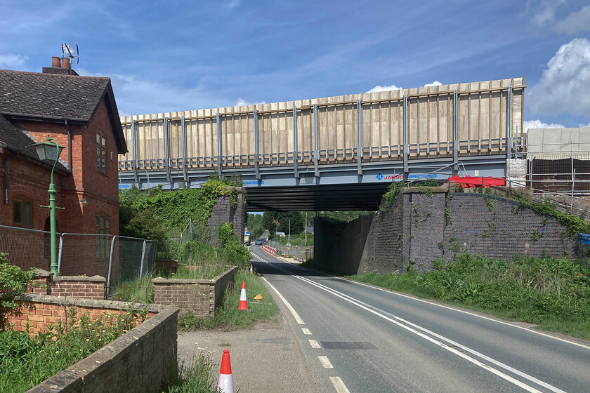 HS2 temporary bridge over A4421, Newton Purcell 
 As part of the construction phase of HS2, a temporary bridge has been installed across the A4421 at Newton Purcell in Buckinghamshire. The bridge enables contractors to go about their work without interfering with the public roads. The rather utilitarian bridge has simply been dropped onto the previous GCR embankments and brickwork. To the immediate left is one of the many, now empty, buildings that have been compulsorily purchased by HS2, a process that has caused so much upset and angst. 
 Keywords: HS2 temporary bridge over A4421 Newton Purcell Great Central Railway GCR