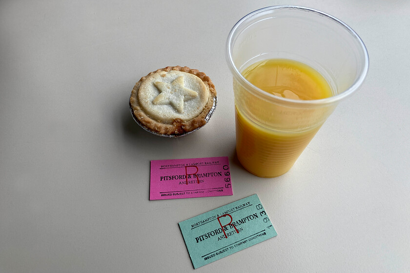 Tickets, Pitsford & Brampton return 
 Our tickets to travel on the Northampton and Lamport Railway were complimented by an orange juice and mince pie. Notice that the tickets are in different colours. My wife passed a birthday milestone this year thus meaning that she is eligible for discount travel on this preserved line. By next New Year, both tickets will be the same colour! 
 Keywords: Tickets Pitsford & Brampton return