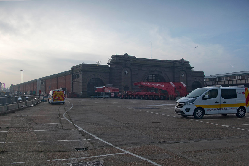 Former Dover Marine station 
 Looking into the sun and the sea mist, the closed Dover Marine station is seen still proudly standing. The archways were were the railway tracks entered the station carrying passengers to and from in order to catch cross-channel ferries. In December 1989 I travelled through from Victoria to Dover Marine in order to catch a ferry to Oostende thence a sleeper service across Europe to Budapest changing at Vienna West (Wien Westbahnhof) station. 
 Keywords: Dover Marine station