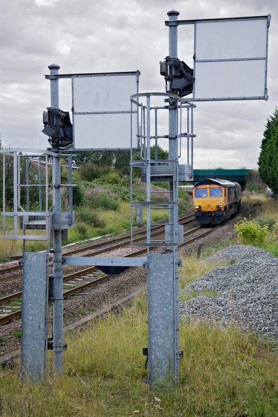 66701, 12.45 Drax-Tyne Coal Yard (4N61), Billingham crossing foorbridge 
 Despite the resignalling of the Durham Coast route between Sunderland and Teeside coming sooner than later Network Rail has invested in some new mechanical signalling. The rather over-engineered galvanised signal posts seen here with their vast sighting boards represents NR's approach to replicating Victorian technology in the twenty-first century! The submissive post to the left permits access to the Haverton Hill branch itself controlled by Belasis signal box. The taller post that is pulled off is for the route towards Sunderland. 66701 is seen leading the 4N61 14.45 Drax power station to Tyne Coal Yard empties. I am not sure if this train will be collecting coal to return to Drax or biomass with the power station now into stage two of its complete conversion to burning the pulped wood pellets imported through Port of Tyne. 
 Keywords: 66701 12.45 Drax-Tyne Coal Yard 4N61 Billingham crossing footbridge GBRf GB Railfreight