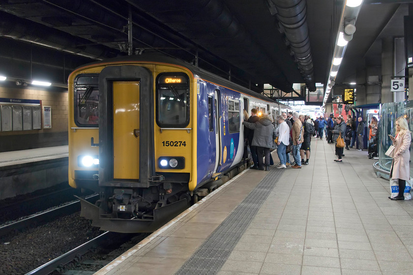 150274, NT 16.14 Rochdale-Clitheroe (2N52, 9L), Manchester Victoria station 
 I am asking a lot of the camera deep inside the depths of Manchester Victoria station! 150274 pauses with the cross-Manchester 16.14 Rochdale to Clitheroe service. This two-car unit was not suitable for this particular working with the train absolutely packed as seen here with passengers queuing to board the train for their Friday night journey home. 
 Keywords: 150274 16.14 Rochdale-Clitheroe 2N52 Manchester Victoria station