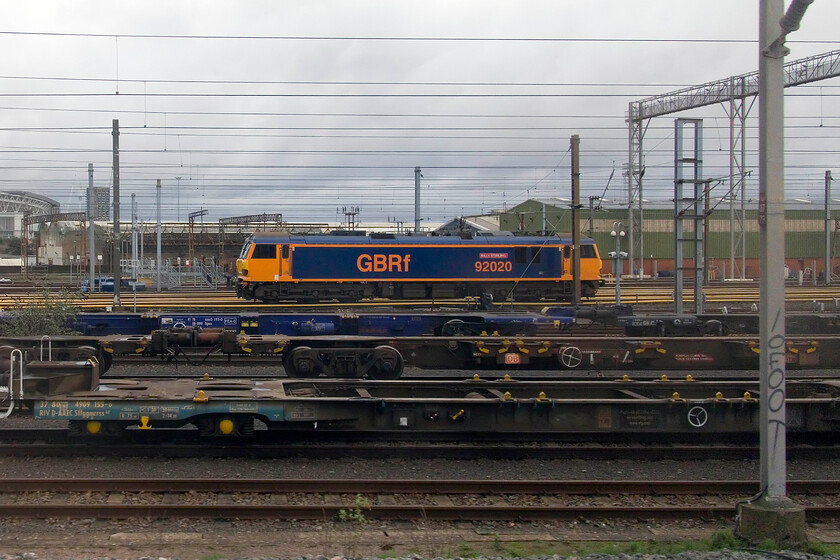 92020, stabled, Wembley Yard 
 A side-on view of GBRf's 92020 'Billy Stirling' standing in Wembley Yard. At present, these locomotives are the most powerful on the network but remain chronically under-utilised. This locomotive was named in 2021 in Mossend Yard as part of COP26 in Glasgow. The naming was covered in an article by Rail Advent, to quote, 'Billy Stirling is the third generation of the 151-year-old family-owned operator, Peter D. Stirling Limited. Billy successfully introduced rail involvement into the company, resulting in the Peter D. Stirling operation moved to Mossend in 1981. Under Billy's guidance, the operator continued to thrive, resulting in the MIPR of today.' 
 Keywords: 92020 stabled Wembley Yard Billy Stirling GBRf