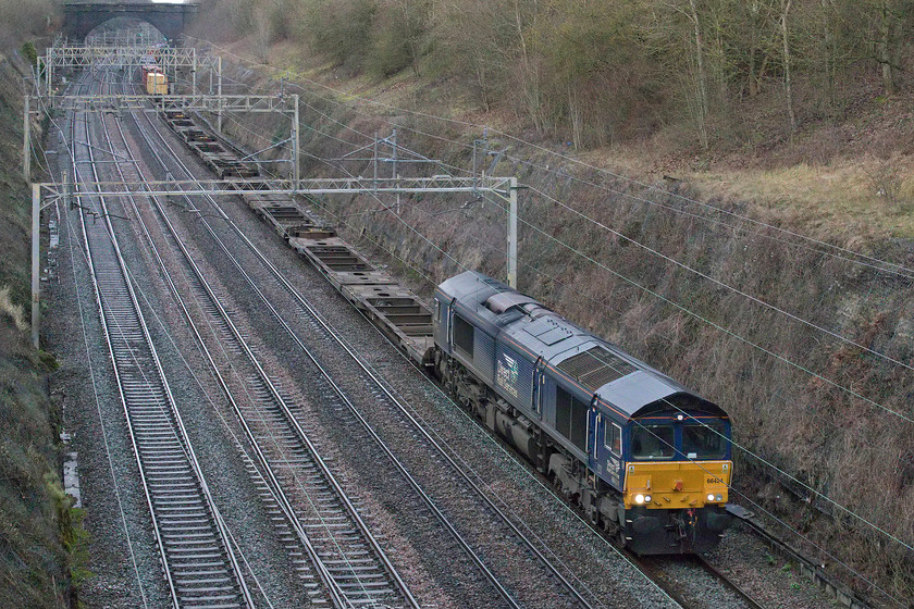 66424, 13.09 DIRFT-London Gateway (4L48, 31L), Hyde Road bridge 
 66424 leads the late-running 13.09 Daventry to London Gateway Tesco Express Freightliner through Roade cutting viewed from the village's Hyde Road bridge. For the last couple of Sundays, this service did not run and that was odd as it's usually one of the most dependable workings. Today, it has returned but is very lightly loaded being less than half full. Perhaps this is a combination of the time of year, the UK leaving the European Union and the COVID effect? 
 Keywords: 66424 13.09 DIRFT-London Gateway 4L48 Hyde Road bridge Tesco Express DRS Direct Rail Services