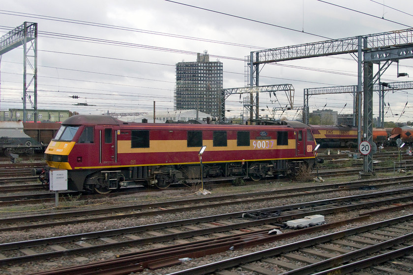 90037 & 66083, stabled, Wembley yard 
 Passing Wembley yard revealed only two locomotives stabled. Still wearing its red and gold EWS livery 90037 'Ford - Spirit of Dagenham' waits its next call with 66083 tucked behind it. 
 Keywords: 90037 66083 Wembley yard