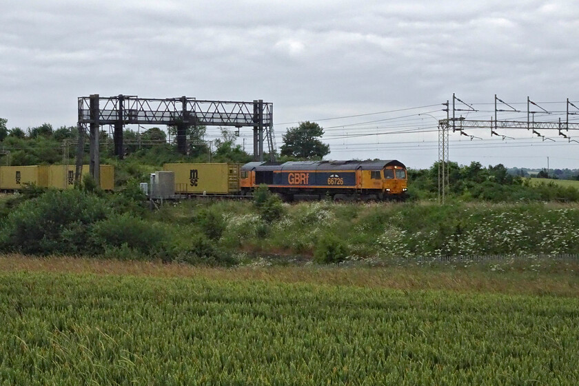 66726, 12.18 London Gateway-Hams Hall (4M47, 4L), between Roade & Ashton 
 66726 'Sheffield Wednesday' passes the fields of south Northamptonshire between Roade and Ashton leading the 4M47 12.18 London Gateway to Hams Hall service. Unfortunately, with such flat light under grey skies, the image is hardly one that stands out. However, if the sun had been out this angle would have been hopelessly back-lit looking southwest. I was to see the same locomotive on the same working three days later but in a very different light, see.... https://www.ontheupfast.com/p/21936chg/30057250464/x4-66726-12-18-london-gateway-hams 
 Keywords: 66726 12.18 London Gateway-Hams Hall 4M47 between Roade & Ashton Sheffield Wednesday