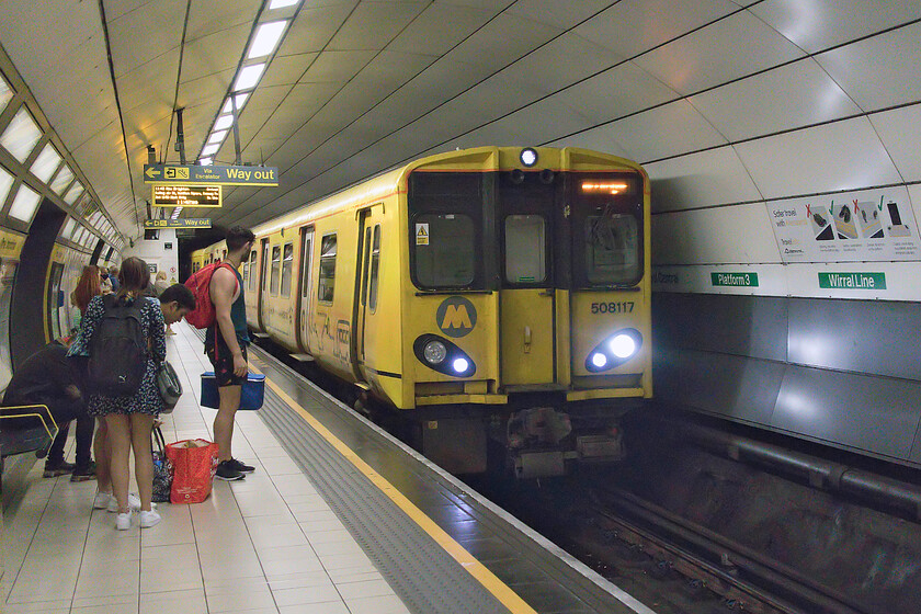 508117, MR 11.16 New Brighton-New Brighton (2N17, 2E), Liverpool Central station 
 Deep under Liverpool's streets are the Wirral Line platforms at Central station. 508117 arrives at the station working the 11.16 New Brighton circular return service that my wife and I took to its destination with us first plunging ever deeper underground so as to pass under the Mersey. Notice the other day-trippers on the platform waiting to board the train also hoping for a day (or afternoon by now!) on the sands at New Brighton. 
 Keywords: 508117 11.16 New Brighton-New Brighton 2N17 2E Liverpool Central station Merseyrail