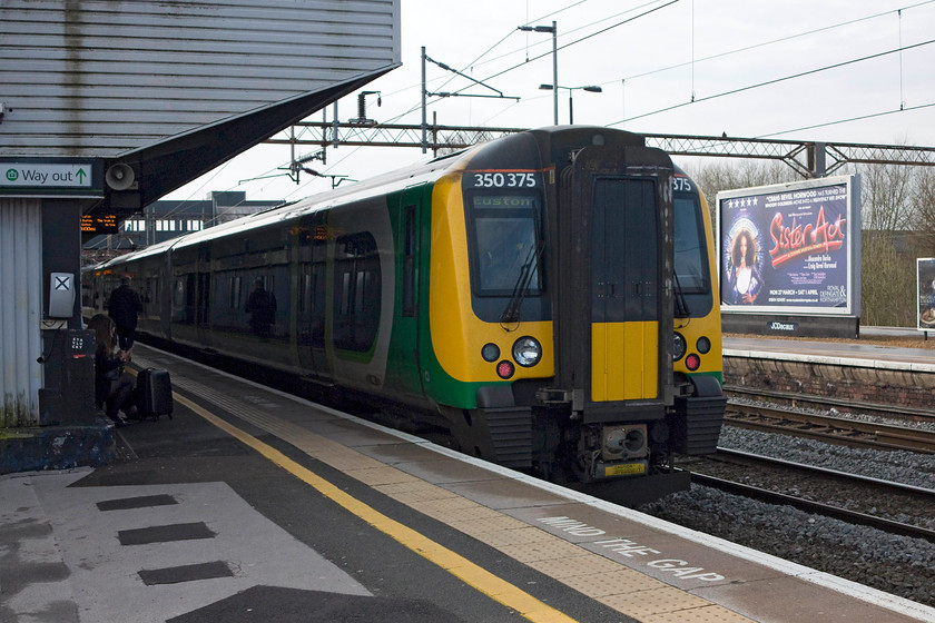 350375, LM 06.49 Crewe-London Euston (2Y00), Northampton station 
 The rear of the 06.49 Crewe to London Euston at Northampton station being worked by 350375. My wife and I have done many trips to London to see plays and musicals, but Sister Act, as seen advertised in the background, is one that we never saw. 
 Keywords: 350375 2Y00 Northampton station