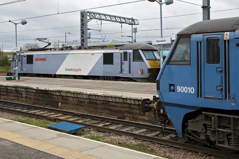 90008, LE 11.30 Norwich-London Liverpool Street (1P33) & 90010, LE 11.00 Norwich-London Liverpool Street (1P31), Norwich station 
 The two faces of Greater Anglia seen at Norwich station. In the background is the newer variant of the joint Dutch and Japanese owned company's livery in the form of 90008 'The East Anglian' that will work the 11.30 to Liverpool Street. In the foreground is this the former livery being worn by 90010 'Bressingham Steam & Gardens' that will leave in the next five minutes with the 11.00 service also to Liverpool Street. Notice the stand of Norwich City's Carrow Road football ground above the roof of 90008. 
 Keywords: 90008 11.30 Norwich-London Liverpool Street 1P33 90010 11.00 Norwich-London Liverpool Street 1P31 Norwich station GA Greater Anglia The East Anglian Bressingham Steam & Gardens.