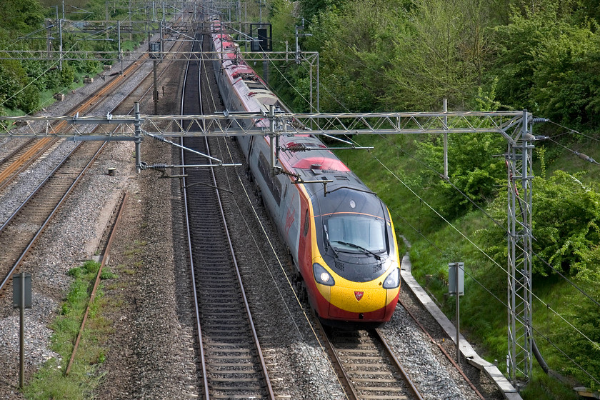 390157, VT 15.17 London Euston-Manchester Piccadilly (1H18), Victoria bridge 
 The 15.17 Euston to Manchester Piccadilly races northwards past Victoria bridge in south Northamptonshire worked by 390157 'Chad Varah'. As it's the early May, the landscape has turned a very lush shade of green as everything bursts into its seasonal life. 
 Keywords: 390157 15.17 London Euston-Manchester Piccadilly 1H18 Victoria bridge Chad Varah Pendolilno