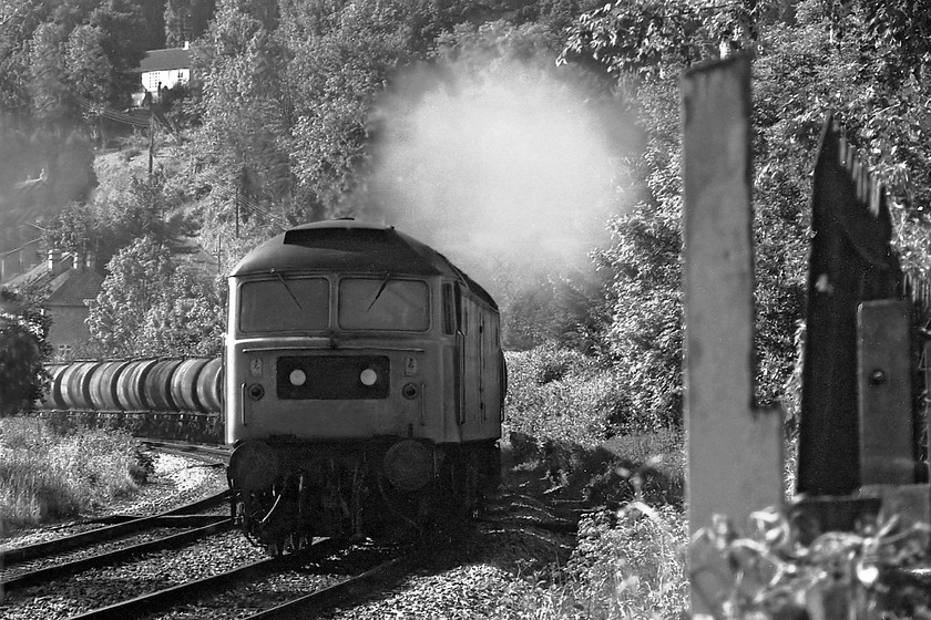 47060, down tanker train, Limpley Stoke 
 47060 opens up to leave smoke screen in the Avon Valley at Limpley Stoke. The picture is taken standing in the old station car park looking over the railings and using my Helios 135mm zoom lens. 47060 was a Bristol Bath Road locomotive at this time and it kept this number until it was selected to become 57006 in December 1999. After use with Freightliner it became a DRS locomotive being used for railhead and nuclear flask work. At the time of writing, it future is uncertain as it remains stored. 
 Keywords: 47060 down tanker train Limpley Stoke