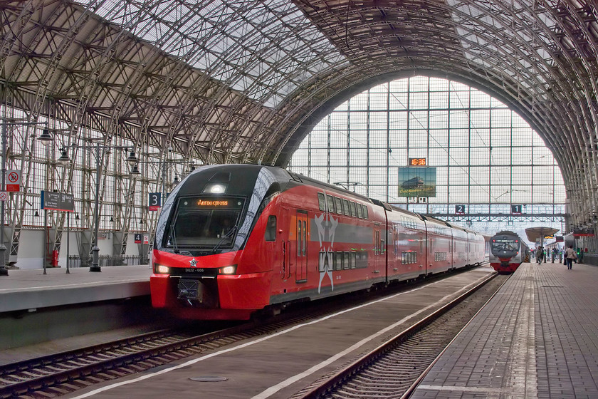 ESH2-006, 16.00 Vnukovo airport-Moscow Kiyevsk Aeroexpress, Moscow Kiyevsky station 
 Under the grand train shed of Moscow Kiyevsk station, the 16.00 from Vnukovo airport Aeroexpress comes to a halt. It has just made the thirty-five-minute journey non-stop from the airport with the cost being a mere 6; Heathrow Express (and other operators), are you listening? The service is formed by ESH2-006, one of the Stadler double-decker units introduced to great fanfare in 2017. This particular set is a six-car unit but there are also some four-car units in operation on this route. 
 Keywords: ESH2-006, 16.00 Vnukovo airport-Moscow Kiyevsk Aeroexpress, Moscow Kiyevsky station