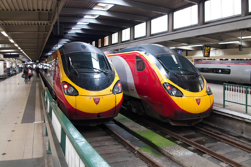 390122, VT 10.30 London Euston-Glasgow C (1S52, 5L) & 390138, VT 10.43 London Euston-Edinburgh (9S60, 6L), London Euston station. 
 The last passengers are being called on to the train as 'it is ready to leave' as the station announcer puts it! 390122 'Penny the Pendolino' is ready for the off forming the 10.30 to Glasgow Central. To its right sits 390138 'City of London' that will leave 12 minutes after the Glasgow train for Edinburgh. On this day, both trains arrived only five and six minutes late respectively. 
 Keywords: 390122 1S52 390138 9S60 London Euston station.