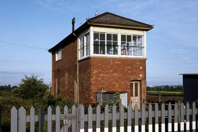 Silk Mill Crossing signal box (GW, 1940) 
 Silk Mill Junction signal box is seen from the rear basking in some welcome evening sunshine. The 1940 built type 12b box controlled a once very busy junction where the Dulverton and Minehead lines diverged. The Minehead branch is still in use of course as the West Somerset Railway but its regular services that have been talked about for many years directly into Taunton have never materialised. Notice the spire of Taunton's parish church St. John The Evangelist to the right-hand side. 
 Keywords: Silk Mill Crossing signal box