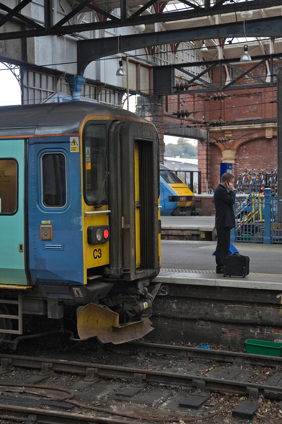 153314, LE 11.36 Norwich-Great Yarmouth & 82105, LE 11.30 Norwich-London Liverpool Street, Norwich station 
 I wonder if the chap on the 'phone is trying to re-arrange his travel arrangements having missed his train? Either way, I like photographs that feature a little human interest in them with the actual trains taking a secondary role. At Norwich 153314 will work the 11.6 to Great Yarmouth with DVT at the rear of what will be the 11.30 to Liverpool Street. 
 Keywords: 153314 11.36 Norwich-Great Yarmouth 82105 11.30 Norwich-London Liverpool Street Norwich station Greater Anglia