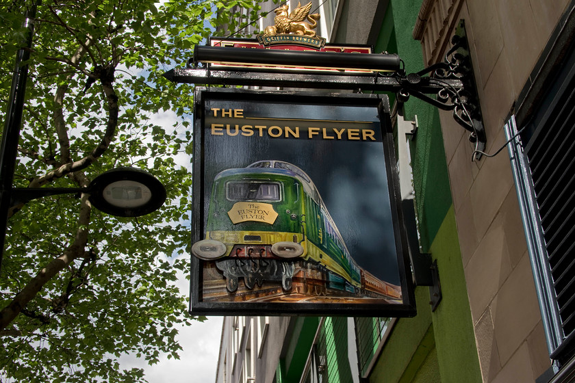 Pub sign, Euston Road 
 I must have passed this pub on the Euston Road between Euston and St. Pancras many times but have never noticed it or its sign. The heritage of pub signs is a whole subject in itself but this sign seemed seemed familiar to me. The slightly out of proportion Deltic in green wearing a Euston Flyer headboard was very similar to the cover of a BR booklet from the 1980s that was produced to commemorate the ending of the Deltics in service. 
 Keywords: Pub sign Euston Road