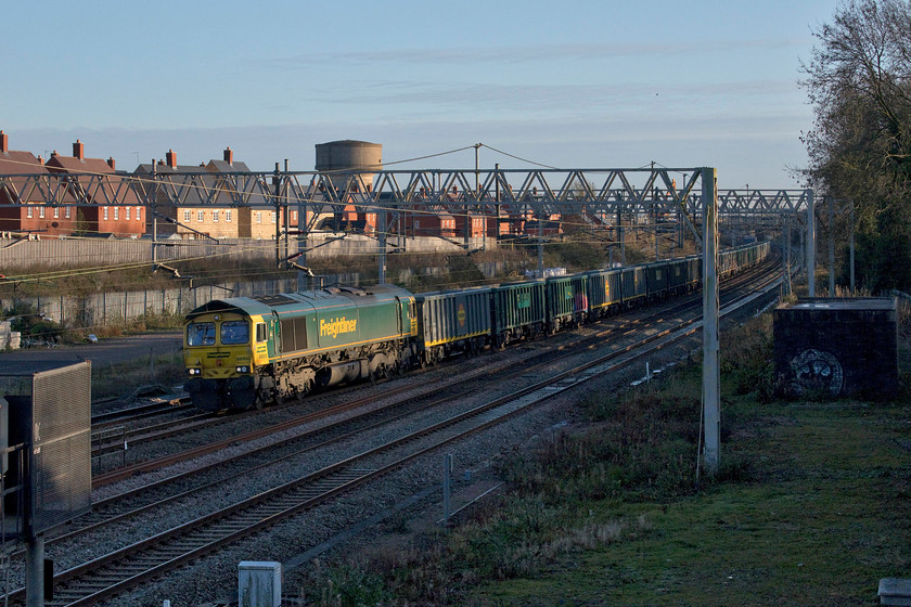 66955, 13.14 Willesden-Barrow Hill (6H50, 4L), site of Roade station 
 I had been tracking the progress of this one-off working since it left Willesden Yard earlier in the afternoon. 66955 leads a long rake of MWA open wagons that were built at the Greenbrier Europe factory in Poland with the first ones being delivered back in 2016. They were not quite new builds as the bogies were largely recycled having been removed from redundant HHA coal hoppers. Many of the wagons in this rake were absolutely covered with graffiti whilst others were left untouched. The 6H50 13.14 Willesden to Barrow Hill working is seen passing Roade in lovely winter light. Thanks to Mike for the reporting number. 
 Keywords: 66955 13.14 Willesden-Barrow Hill site of Roade station