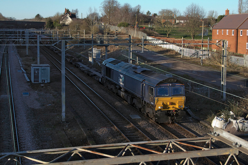 66425, 13.09 DIRFT-Ripple Lane (4L48, 54L), site of Roade station 
 66425 is a regular performer on this Sunday only Freightliner working. The 4L48 leaves Daventry's rail freight terminal at lunchtime, timetabled for 13.09, and stops at Ripple Lane. Later it works on to the new London Gateway terminal in the Thames estuary. As the winter afternoon sun gets low in the sky, it just manages to catch the front of the locomotive as it emerges from Roade cutting at the site of the former station. 
 Keywords: 66425 13.09 DIRFT-Ripple Lane 4L48 site of Roade station