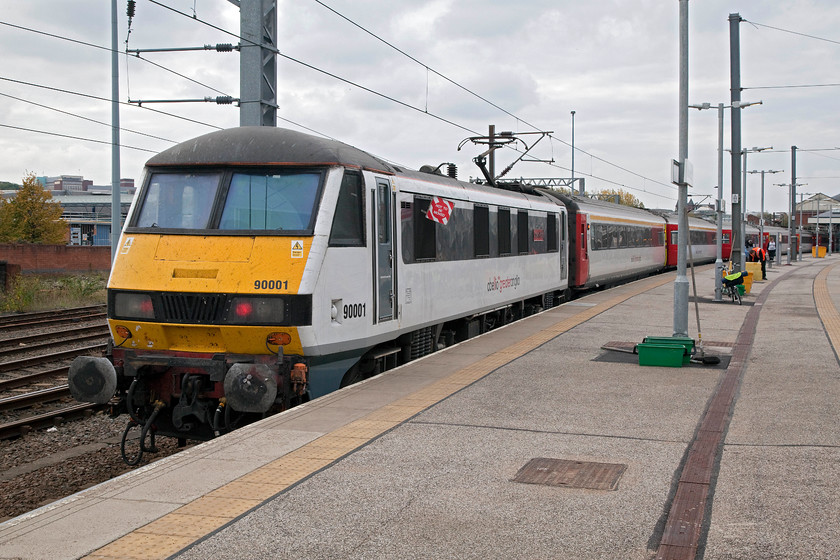 90001, LE 0015.0030 Norwich-London Liverpool Street (0001P0049), Norwich station 
 90001 'Crown Point' still has its taillights illuminated while it sits at Norwich station's platform one. It has fifteen minutes before departure with the 15.30 to London Liverpool Street so the platform crew will continue their work replenishing the water tanks and clearing the coaches of rubbish. Notice my Brompton bike leaning against the second lamppost along the platform. 
 Keywords: 90001 15.30 Norwich-London Liverpool Street 1P49 Norwich station