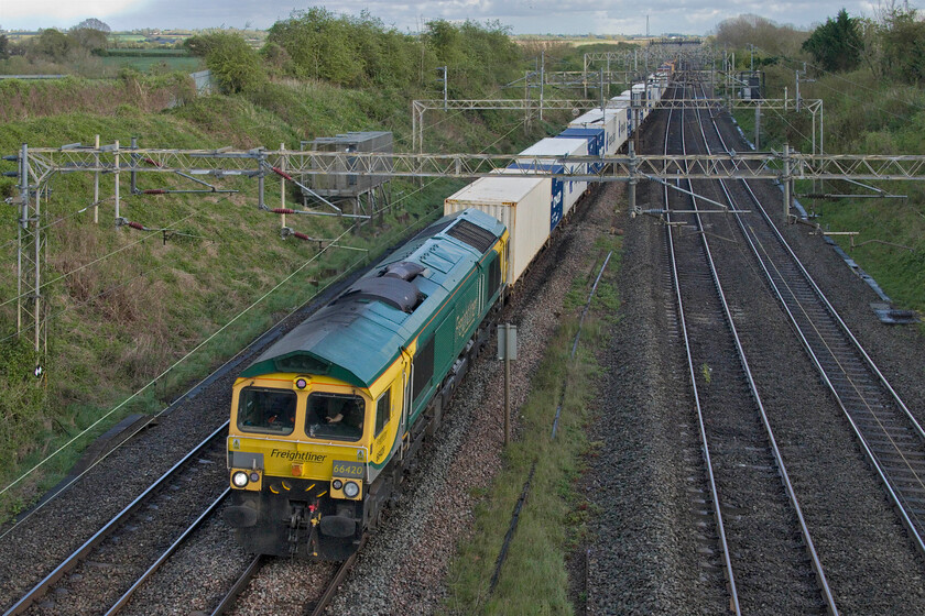 66420, 12.57 London Gateway-Garston (4M56, 46E), Victoria bridge 
 The 4M46 12.57 London Gateway to Garston Freightliner catches some late afternoon sunshine as it passes a chilly (for mid-April that is) Victoria bridge just south of Roade. As well as being extremely well loaded the 4M46 was also running early, something that it continued to do so to its Merseyside destination. 
 Keywords: 66420 12.57 London Gateway-Garston 4M56 Victoria bridge Freightliner