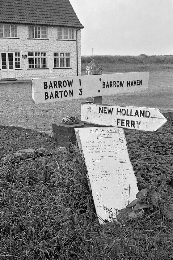 Road sign & notice, Haven Inn, Barrow Haven 
 Barrow Haven is a small village that is a little isolated on the south bank of the Humber estuary in North Lincolnshire. The village has few services but maintains a tiny railway station and the Haven Inn, seen in the background of this photograph, is still open, see..... https://www.facebook.com/TheHavenInn/ . Notice the rather crude handwritten notice board leaning against the road sign dubbed a British Rail Notice! It is reminding passengers that the Humber Ferry will close next week and outlines the revised train times that will be in operation from then. I love the amateur nature of this notice board, was it that BR had done nothing official to help customers and that a local employee thought that something ought to be done? 
 Keywords: Road sign notice Haven Inn, Barrow Haven