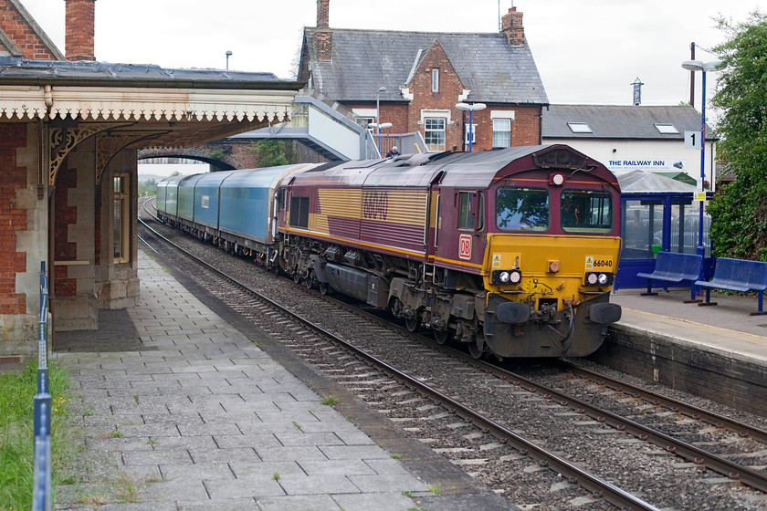 66040, 14.42 Didcot-Morris Cowley, Culham station 
 66040 heads the 14.42 Didcot to Morris Cowley working. This is a short freight conveying empty car carrier wagons the meagre distance of some twelve miles! The train is seen passing through Cullham station between Didcot and Oxford. Notice The Railway Inn in the background, Andy and I did not have time to sample its delights! 
 Keywords: 66040 14.42 Didcot-Morris Cowley Culham station