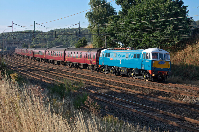 86259, outward leg of The Cumbrian Mountain Express, 07.08 London Euston-Carlise (1C96, 10E), Old Linslade 
 I never tire of seeing classically restored 86259 'Les Ross/Peter Pan' in action on its natural home, the WCML. Luckily for me it sees regular use throughout the year so I always make the effort together out and see it! Here it passes Old Linslade leading the outward leg of the Cumbrian Mountain Express that left Euston at 07.08 heading for Carlisle. I love the early morning lighting in this photograph but notice the tinder dry embankments and fields caused by a prolonged period of drought. Also notice that for some odd reason the train has been given the strange reporting number of 1C96 rather than its more usual 1Z86; any information as to why? 
 Keywords: 86259 The Cumbrian Mountain Express 07.08 London Euston-Carlise 1C96 Old Linslade Les Ross Peter Pan