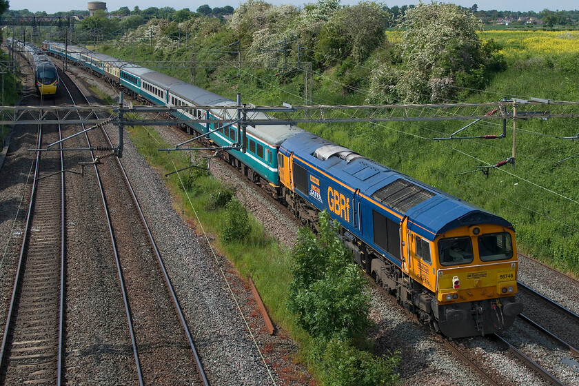 66748 & 66765, 14.20 Wembley Reception-Burton-on-Wetmore (5Z68, 3L) & 390020, VT 14.52 London Euston-Manchester Piccadily (1H27, 15L), Victoria bridge 
 Having been involved in the previous day's Parkeston Panorama charter 66748 'West Burton 50' brings up the rear of the 5Z68 14.20 Wembley Yard to Burton-ot-Wetmore empty stock move. 66765 'Julie Garn' leads the train that is seen passing Victoria bridge just south of Rade in Northamptonshire. 390020 working Avanti's 14.52 Euston to Manchester Piccadilly is seen overhauling the empty stock. 
 Keywords: Julie Garn 66748 66765 14.20 Wembley Reception-Burton-on-Wetmore 5Z68 390020 14.52 London Euston-Manchester Piccadilly 1H27 Victoria bridge West Burton 50