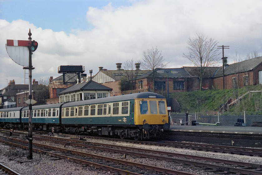 L587, unidentified up working, Newbury station 
 A class 119 DMU set number L587 arrives at Newbury station with a Bedwyn to Paddington working. Behind it is the lovely GW West signal box. Notice on the platform the detritus casually left by the S & T team consisting of new signalling posts and lights; how different today! Also of note is the down fast home with its sighting board, I suspect that this was installed to assist drivers seeing the signal in the late afternoons and early evenings when the sun was setting as they were facing just about due west and they would have been passing at speed through the middle road. 
 Keywords: L587 up working Newbury station