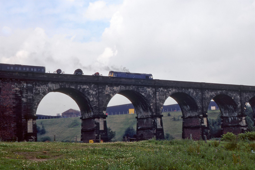 Class 25, up PW train, Sankey viaduct SJ568945 
 An unidentified Class 25 trundles across Sankey viaduct heading east with, what appears to be, some sort of permanent way working. The first wagons seem to be carrying electrification wiring with a vintage carriage behind. Sankey viaduct became a Grade I listed structure in 1966 due to its international significance as 'the earliest major railway viaduct in the world'* In this view, looking north-east, some industry is seen behind the viaduct at the top of the ridge. In recent years this large industrial area has been cleared and covered by housing with the first row of the houses affording spectacular views of the viaduct from their gardens and south-west facing windows!

*Sankey Viaduct (L&MR) engineering-timelines.com 
 Keywords: Class 25 up PW train Sankey viaduct SJ568945