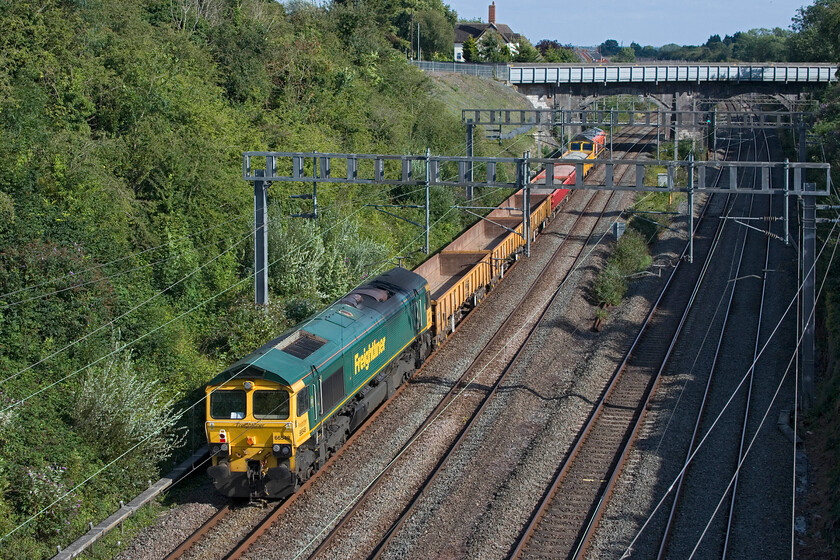 66548 & 66502, 15.44 Bescot Yard-Camden Junction (6Y66, 9E), Hyde Road bridge 
 A short and lightly loaded 6Y66 infrastructure train passes through Roade. It's almost that I planned for the 15.44 Bescot Yard to Camden working to fit into the gap between Hyde Road bridge (where I am standing) and the former A508 bridge - pure fluke I can assure you! 66548 is seen un-powered at the rear of the train with 66502 'Basford Hall Centenary 2001' leading. 
 Keywords: 66548 66502 15.44 Bescot Yard-Camden Junction (6Y66, 9E) Hyde Road Basford Hall Centenary 2001