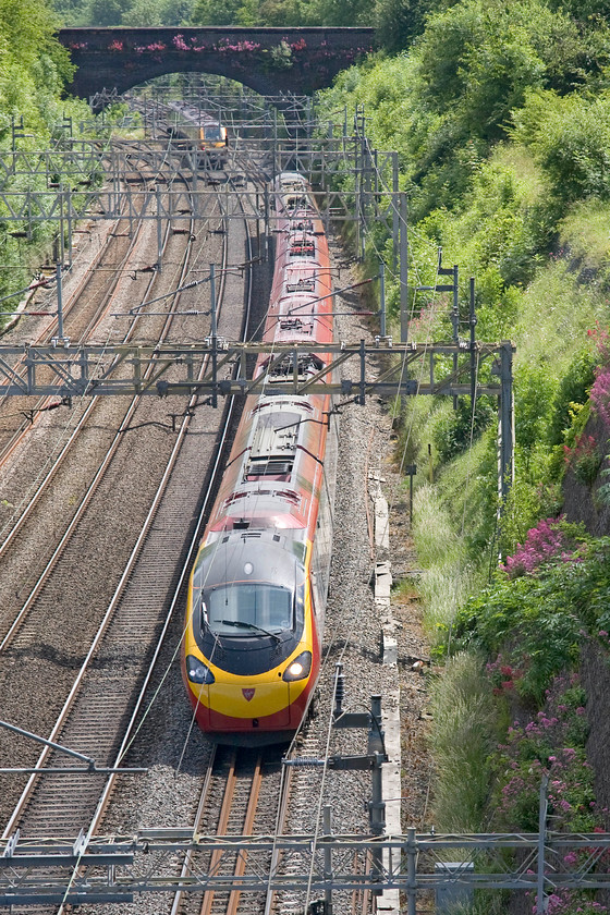 Class 390, VT 13.17 London Euston-Birmingham New Street (1H11), Roade cutting 
 A class 390 heads north through Roade cutting with the 13.17 Euston to Birmingham New Street train. A class 221 Voyager is just passing under Hyde Road bridge heading south. 
 Keywords: Class 390 13.17 London Euston-Birmingham New Street 1H11 Roade cutting Virgin West Coast Pendolino Class 221 Voyager