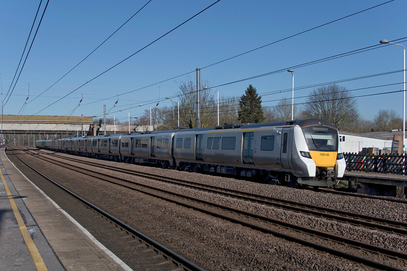 700145, TL 12.24 Peterborough-Horsham (9J33, 7L), Arlesey station 
 The length of the twelve-car Class 700s is clear to see in this image taken at Arlesey. 700145 arrives at the station working the 12.24 Peterborough to Horsham Thameslink service. Notice the anti-slip treatment on the platform to the left testament to the fact that, despite the sunny appearance, it was a chilly day within a spell of much colder and frosty nights. 
 Keywords: 700145 12.24 Peterborough-Horsham 9J33 Arlesey station Thameslink