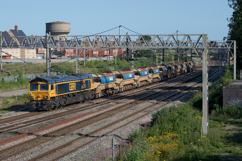 66751, 14.53 Bescot Yard-Wembley Yard (6G52, RT), site of Roade station 
 On a glorious summer afternoon, 66751 'Inspiration Delivered Hitachi Rail Europe' is dead in tow on the 6G52 14.53 Bescot Yard to Wembley infrastructure working. The train is seen passing the site of Roade station from a footbridge that spans the lines. The last time that I photographed this locomotive was in somewhat different weather conditions during 2018's Beast from the East event, see.... https://www.ontheupfast.com/p/21936chg/23791615004/x66751-4n61-knottingley-station 
 Keywords: 66751 14.53 Bescot Yard-Wembley Yard 6G52 site of Roade station GBRf GB Railfreight Inspiration Delivered Hitachi Rail Europe