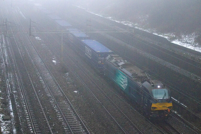 88007, 12.41 DIRFT-Tilbury FLT (4L48, 2E), Roade cutting 
 88007 'Electra' emerges from the fog in Roade cutting leading the daily 4L48 12.41 Daventry to Tilbury Freightliner Terminal Tesco Express. This DRS operated is the balancing working to the train photographed in the previous image and goes through phases of being electrically hauled but more normally is seen with a Class 66 at the front. 
 Keywords: 88007 12.41 DIRFT-Tilbury FLT 4L48 Roade cutting Electra