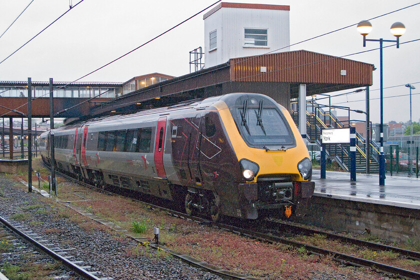 220018, XC 06.30 Birmingham New Street-Newcastle (1E38), York station 
 With the station and platform lights on due to the dark conditions and the rain absolutely torrential taking a photograph of 220018 meant staying under the canopy. The CrossCountry Voyager is seen pausing at York working the 06.30 Birmingham New Street to Newcastle 1E38 service. Yet another distinctly chilly and very wet day that was particularly disappointing for the last week of May! 
 Keywords: 220018 06.30 Birmingham New Street-Newcastle 1E38 York station CrossCountry Voyager