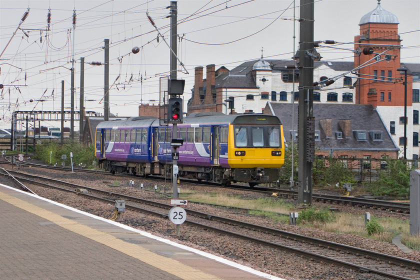 142018, NT 13.16 Nunthorpe-Hexham (2N36), Newcastle station 
 Under grey skies, Northern Trains operated Pacer 142018 arrives at Newcastle station working the 13.16 Nunthorpe to Hexham service. In the background is the Turnbull building, a former printing works now converted into high end appartments. 
 Keywords: 142018 13.16 Nunthorpe-Hexham 2N36 Newcastle station Northern Trains Pacer