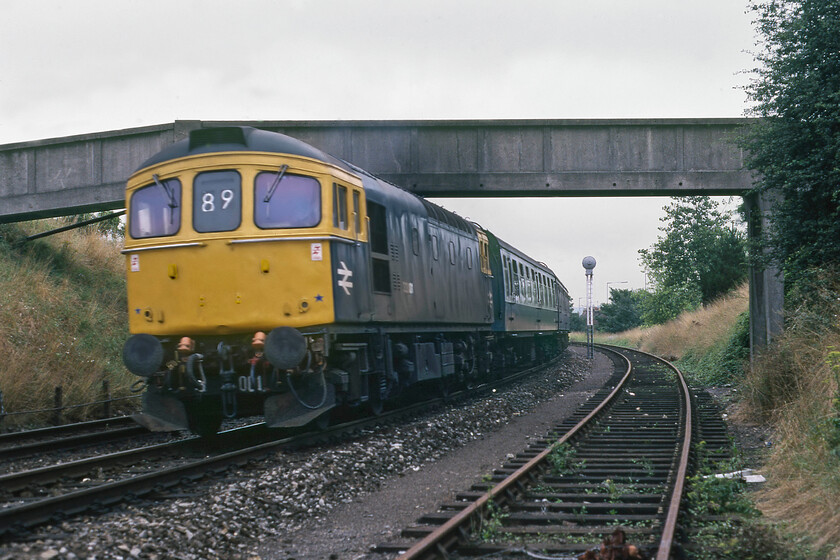 33001, 10.14 Bristol Temple Meads-Portsmouth Harbour (1O69), approaching Salisbury tunnel 
 33001 climbs away from Salisbury on the approach to the tunnel to the east of the town leading the 10.14 Bristol Temple Meads to Portsmouth Harbour service. Notice the banner repeater signal that indicates the position of the home signal on a rather nice bracket signal just behind me. It was needed due to the gradient and the sharp curve that restricted sighting and that all this was located just before the tunnel. Also, notice the concrete footbridge that spans the line that was probably a product of the Southern's concrete manufacturing plant at Exmouth Junction. 
 Keywords: 33001 10.14 Bristol Temple Meads-Portsmouth Harbour 1O69 approaching Salisbury tunnel