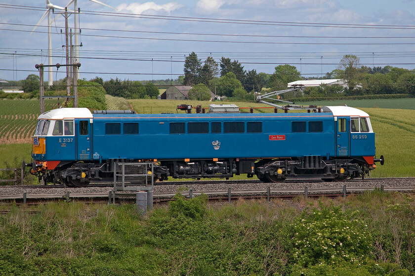 86259, 12.39 Acton Lane Reception Sidings-Rugby CS (0Z68, 7E), Roade Hill 
 Following yet another successful Cumbrian Mountain Express the previous day (see..... https://www.ontheupfast.com/p/21936chg/30027054862/x86259-cumbrian-mountain-express) 86259 'Les Ross (on this side)/Peter Pan' runs light engine on the down fast line between Roade and Ashton in south Northamptonshire. It was returning from Acton Lane in west London where the coaching stock is kept and maintained to Rugby carriage sidings. This side-on view shows the extra set of suspension springs fitted to the AL6s soon after their introduction in the 1960s to counteract poor riding characteristics. 
 Keywords: 86259 12.39 Acton Lane Reception Sidings-Rugby Carriage sidings 0Z68 Roade Hill AL6 AC Eelctric